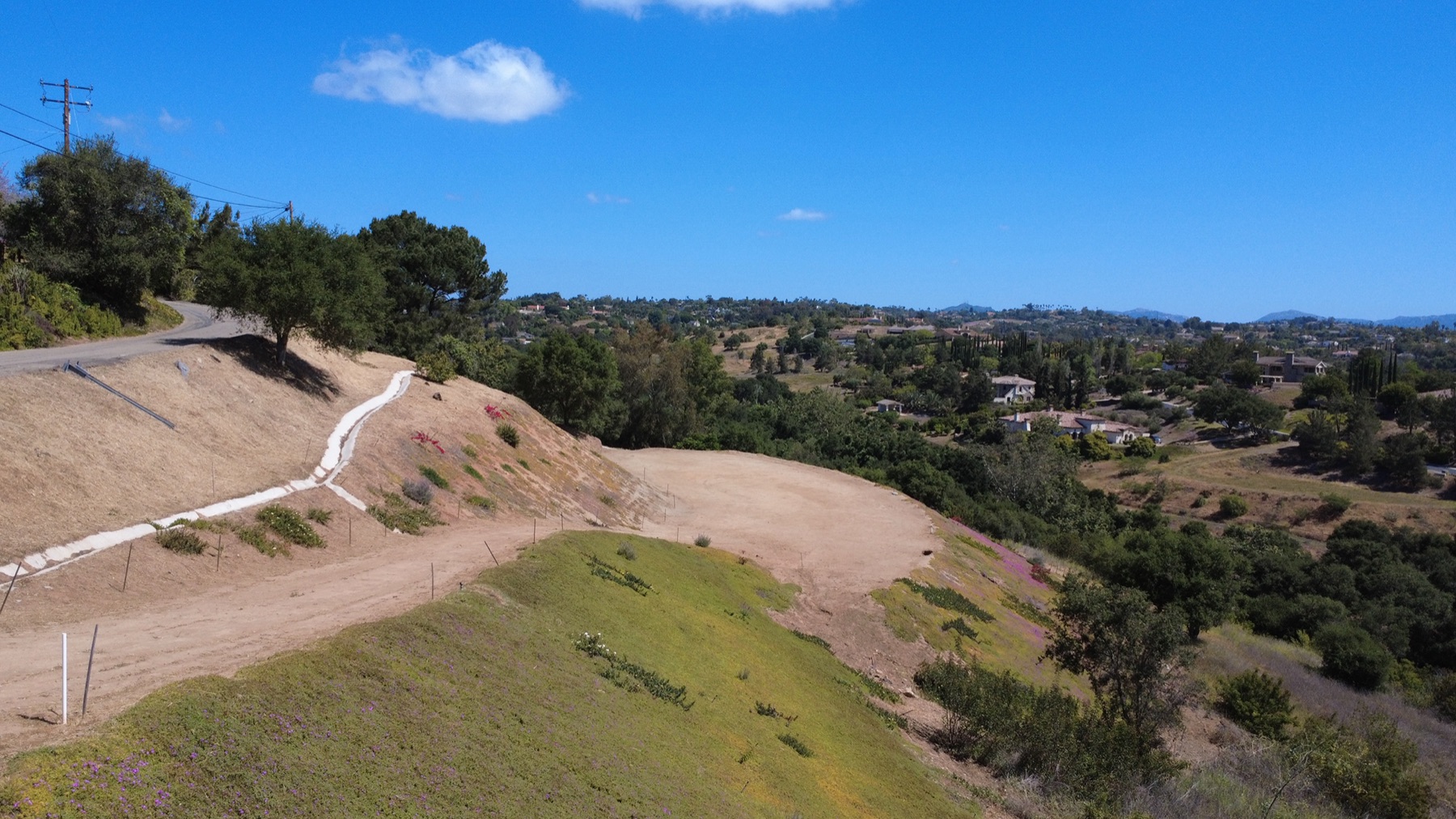 The graded, build-ready pad at Palomar, with panoramic North County valley and mountain views.